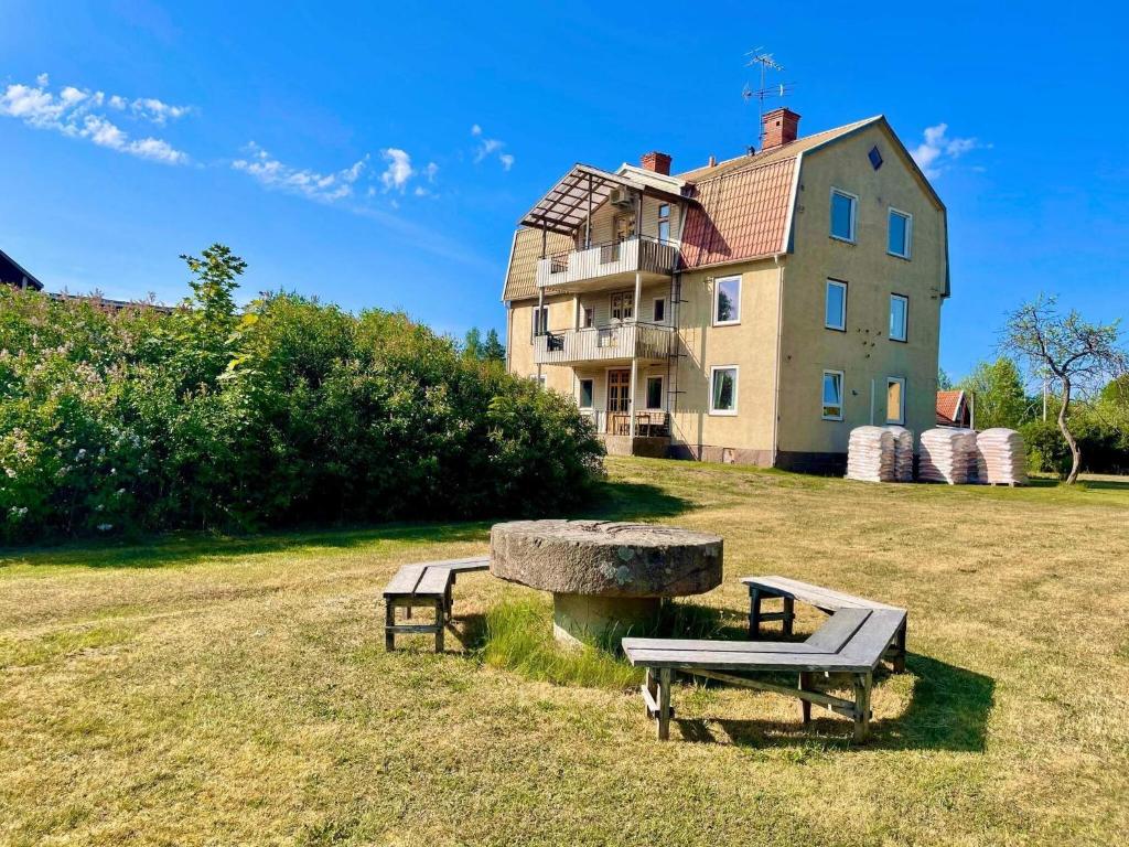 two benches in a field in front of a building at 5 person holiday home in Mörlunda-By Traum in Tulunda