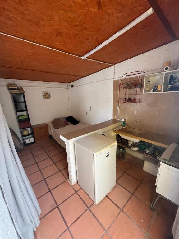 a small room with a bed and a small refrigerator at Monoambiente Caracol chico in Aguas Dulces