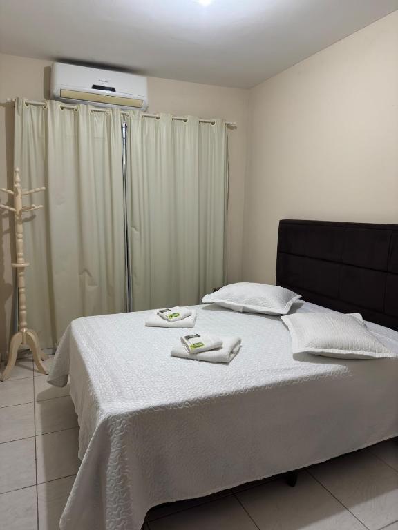 Un dormitorio con una cama con dos toallas encima. en Residencial lara 101, en Itapema