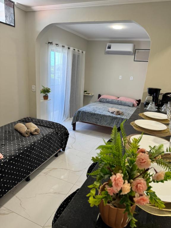 a living room with a bed and a table at Suítes da Orla Hospedagens in Arraial do Cabo
