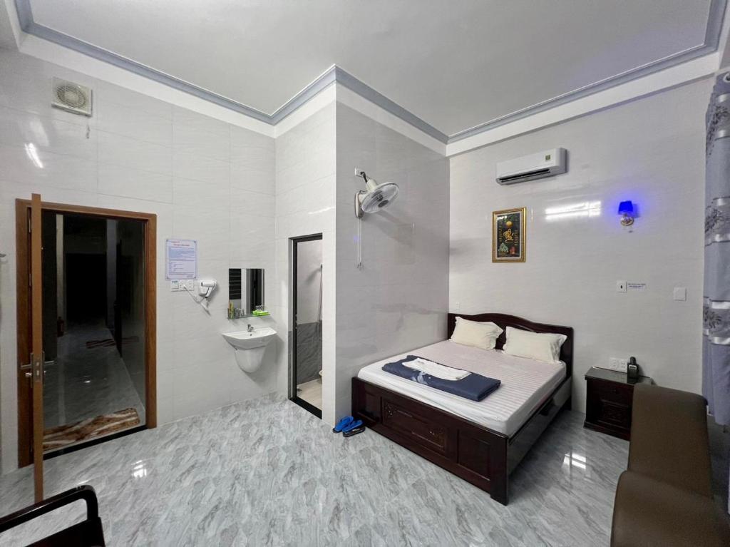a bedroom with a bed and a sink and a toilet at Thiên Tân Motel 2 in Quang Ngai