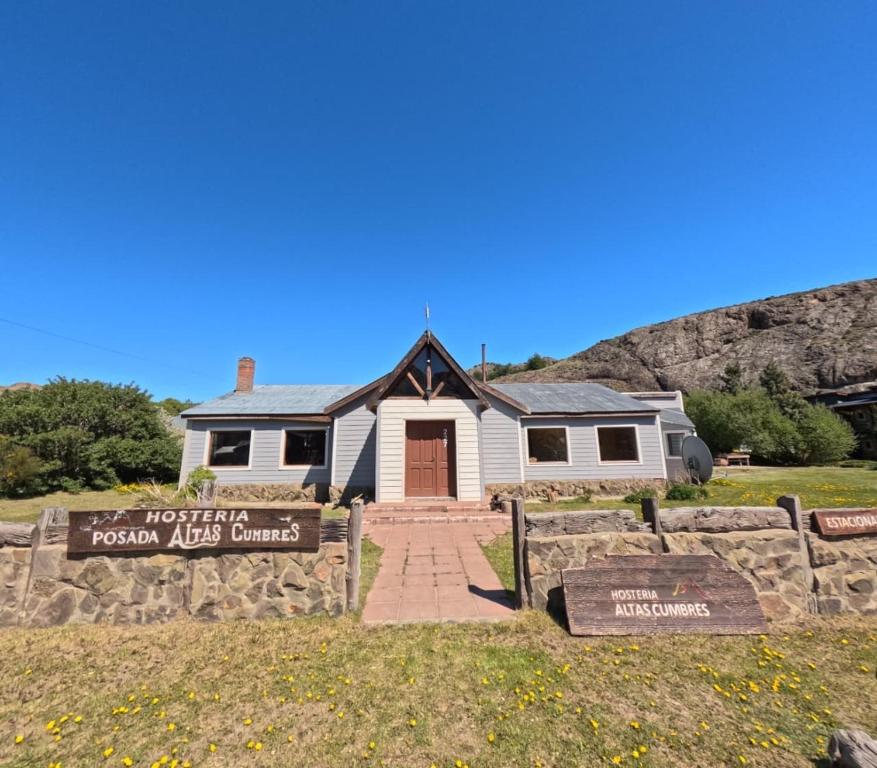 ein Haus mit einem Schild davor in der Unterkunft Hostería Altas Cumbres in El Chalten