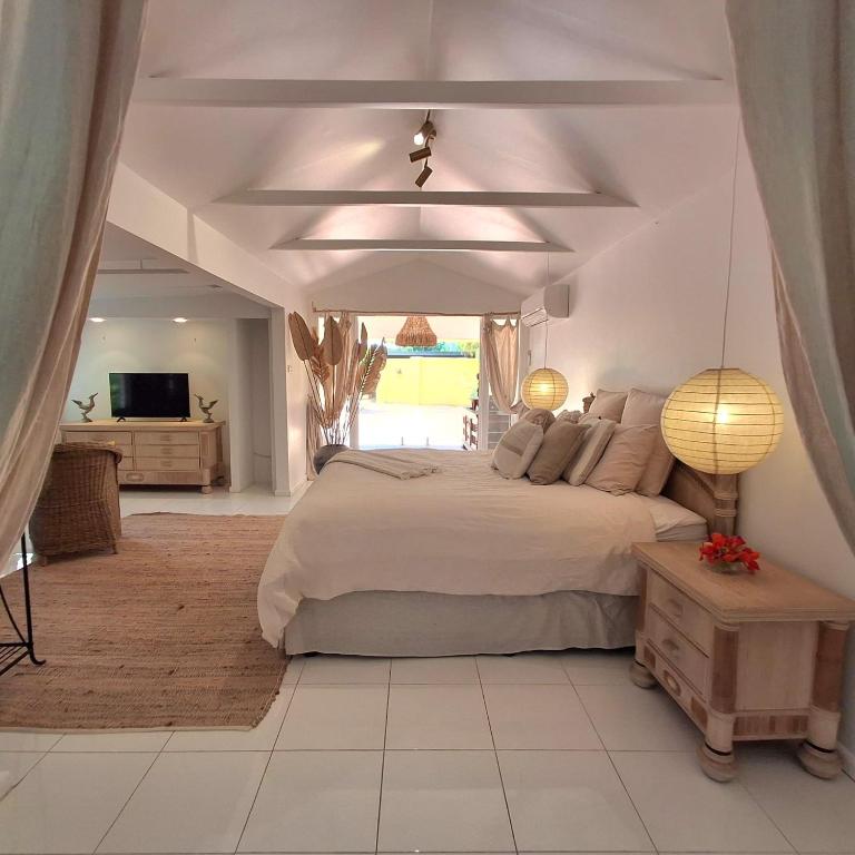 a bedroom with a large bed and a large window at Studio Casablanca in Nelly Bay
