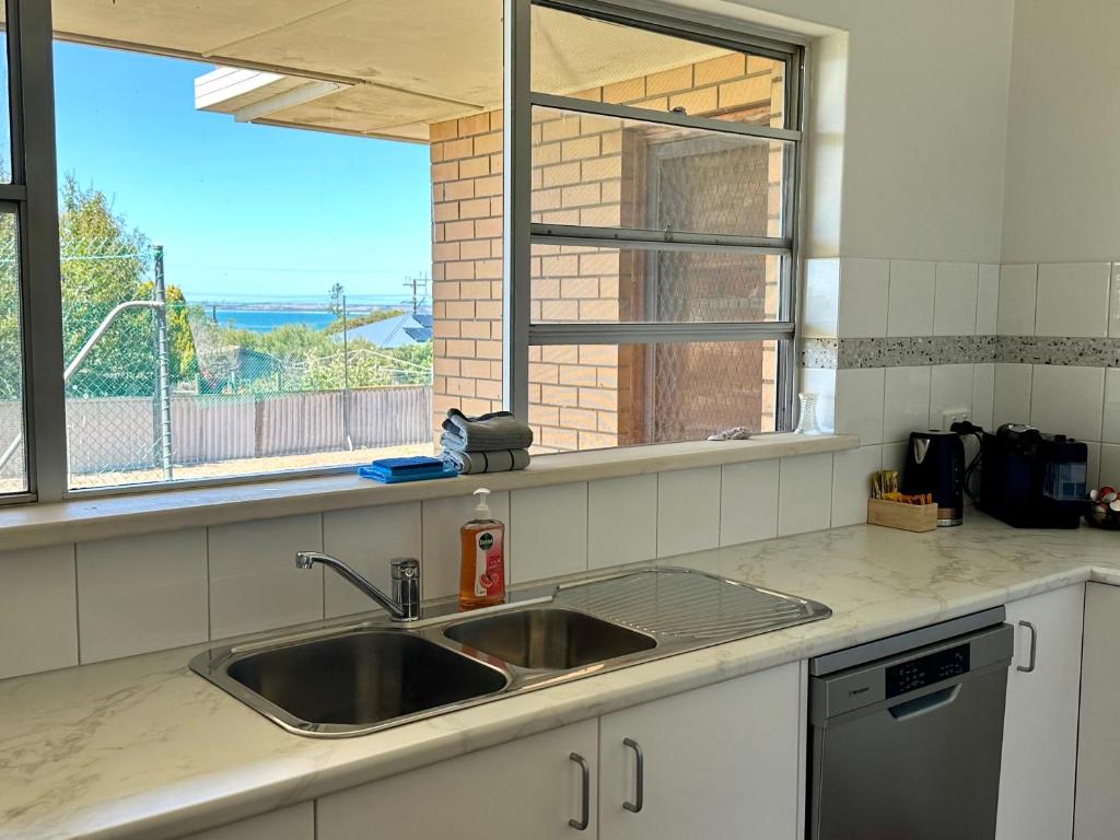 a kitchen counter with a sink and a window at BeeJays Family Getaway in Kingscote