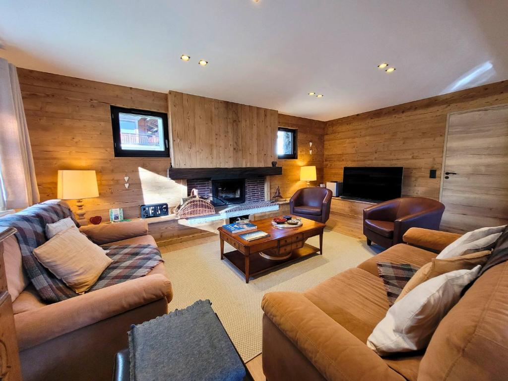 a living room with two couches and a fireplace at Chalet familial rénové, proche centre, capacité 12, parking, WiFi - FR-1-598-195 in Les Gets
