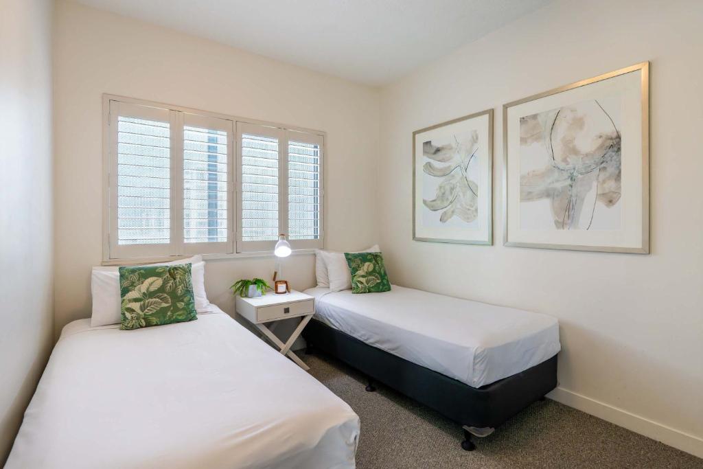 two beds in a room with two windows at BreakFree Royal Harbour in Cairns