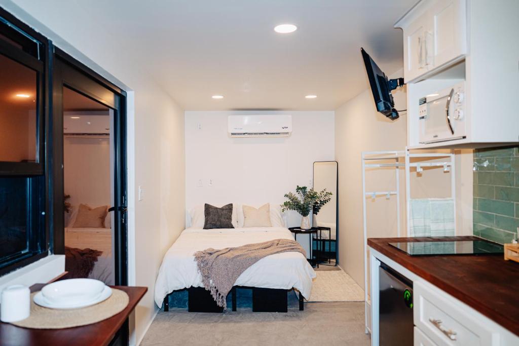 a small bedroom with a bed and a kitchen at Desierto de Acero Containers in San José del Cabo