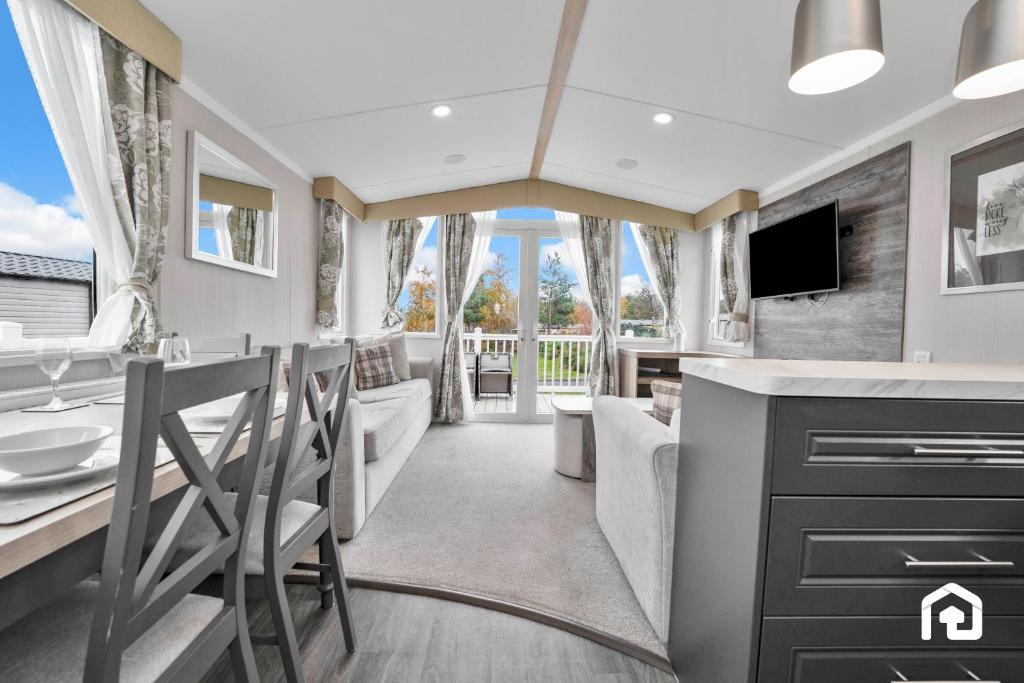 een badkamer met een bad en een wastafel en een tv bij Vacant Nests The Gullane Seton Sands in Port Seton