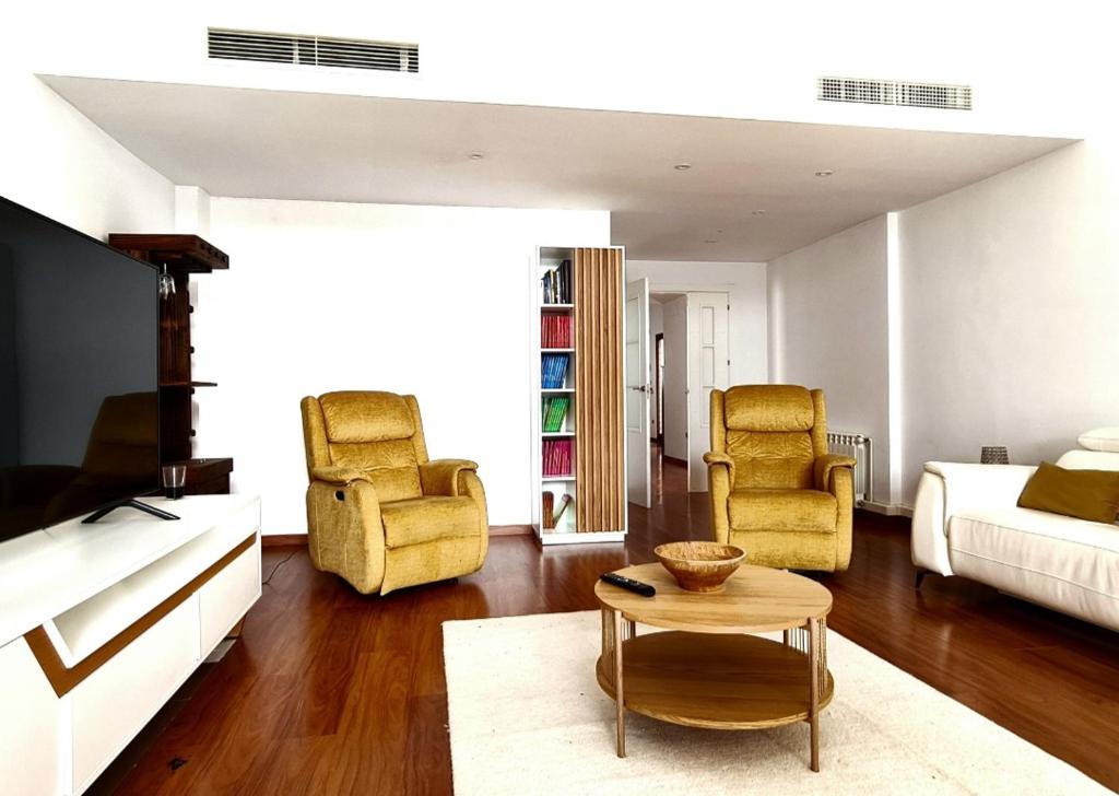 ein Wohnzimmer mit einer Couch und zwei Stühlen und einem Tisch in der Unterkunft Chalet con Piscina de,3 hab in Dílar