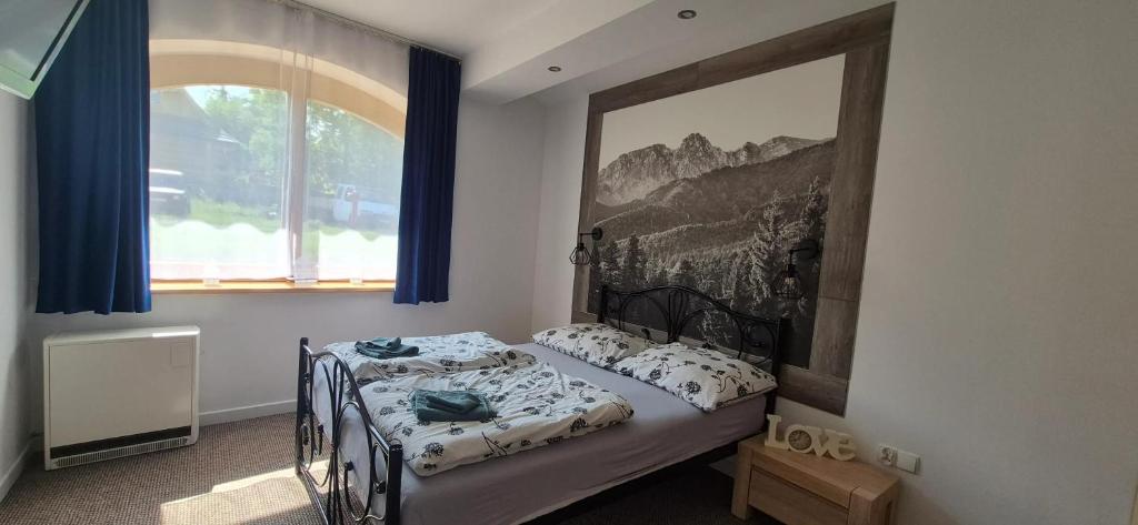 コシチェリスコにあるCozy Apartment in Kościelisko with Mountain Viewの壁に絵が飾られたベッドのある寝室