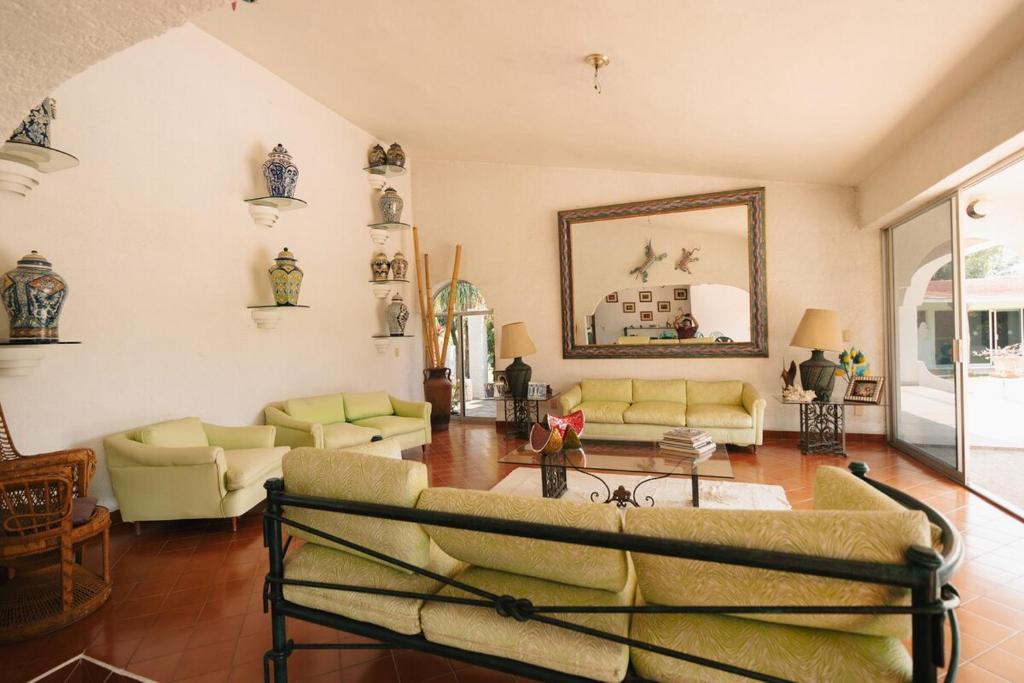 sala de estar con sofás amarillos y espejo en Large House with Pool in Yautepec, 4 Bedrooms, en Yautepec