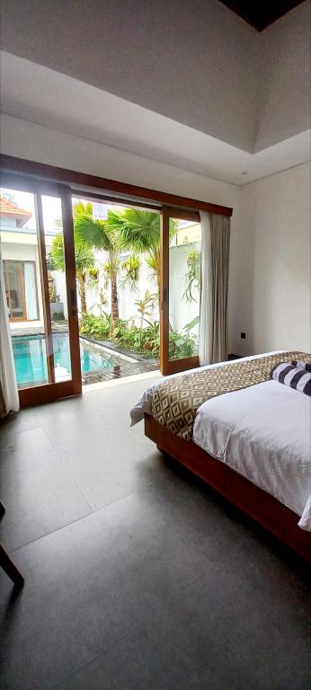 a bedroom with a bed and a view of a pool at La Reina villa in Ubud