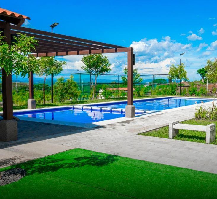 a large swimming pool with a pavilion and green grass at Cozy House! San Miguel in San Miguel
