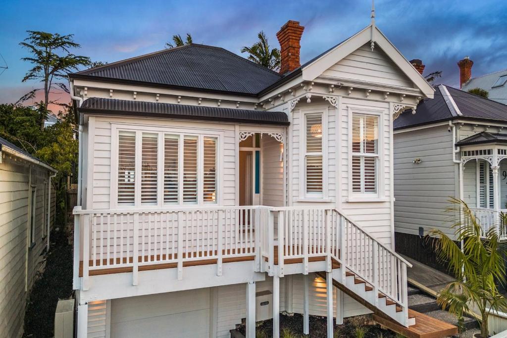 a white house with a porch and a balcony at Luxury Ponsonby Villa in Auckland