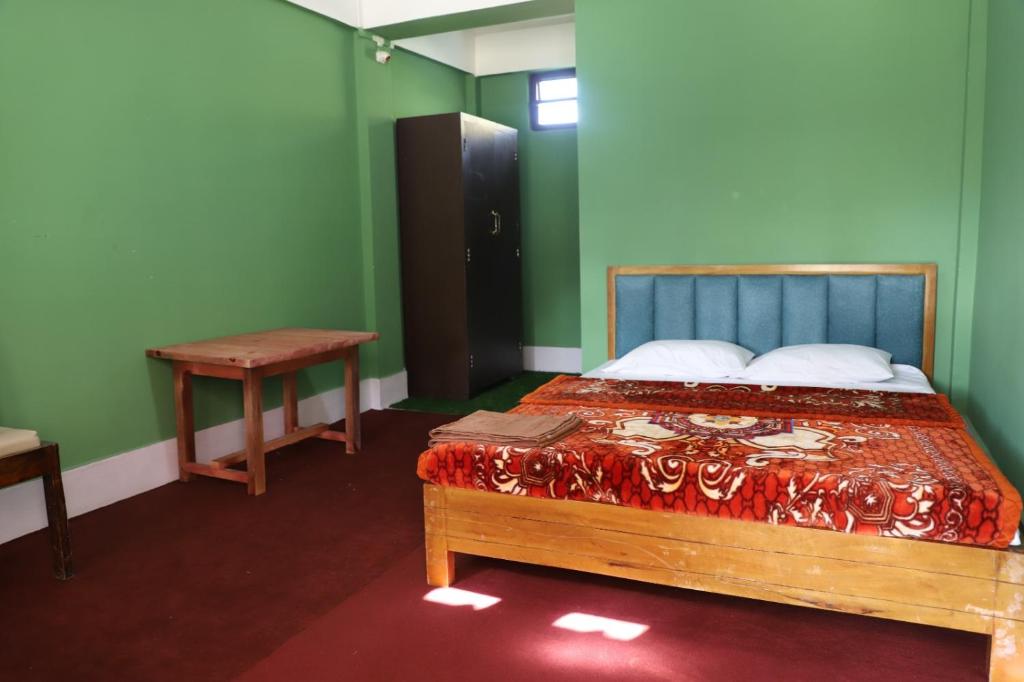 a bedroom with a bed and a table in it at The kamcha Homestay in Bomdila