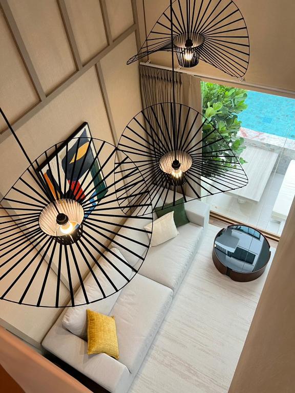 a living room with a couch and two large fans at Swan Private Pool Villa Bangsaen in Ban Thai Don (1)