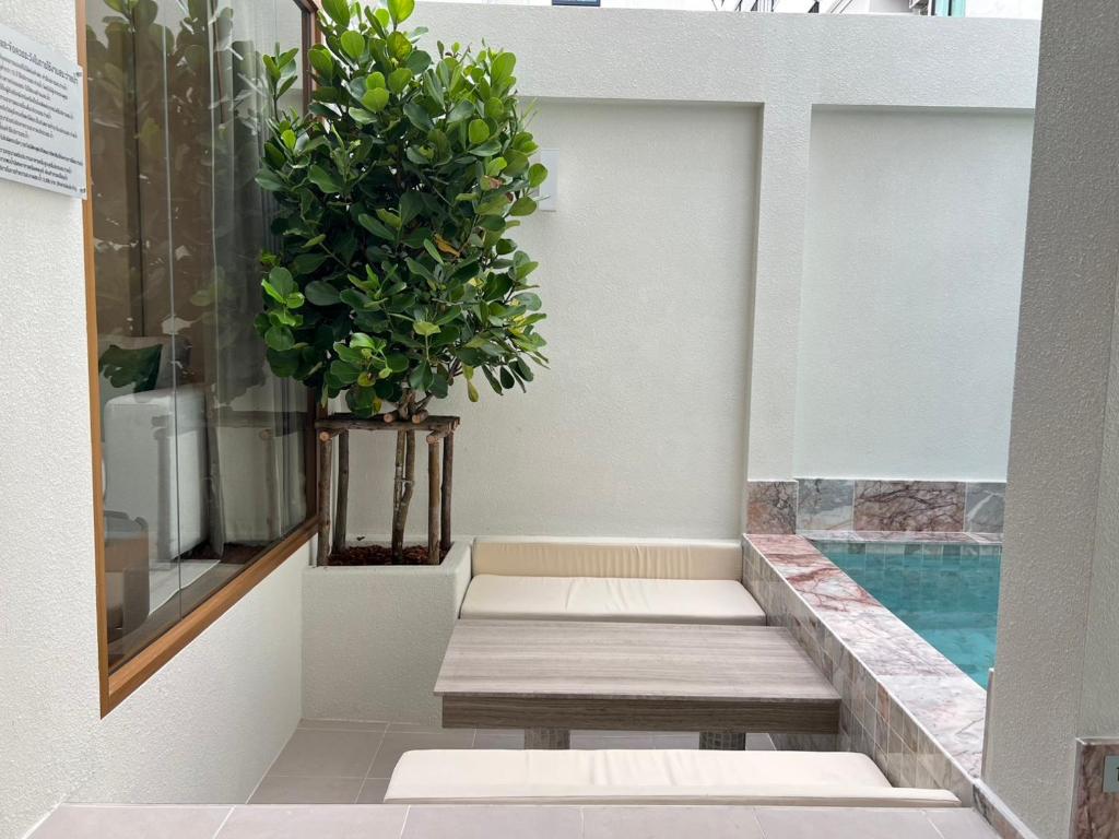 ein Balkon mit Bänken und einer Topfpflanze in der Unterkunft Swan, Private Pool Villa Bangsaen in Ban Thai Don (1)