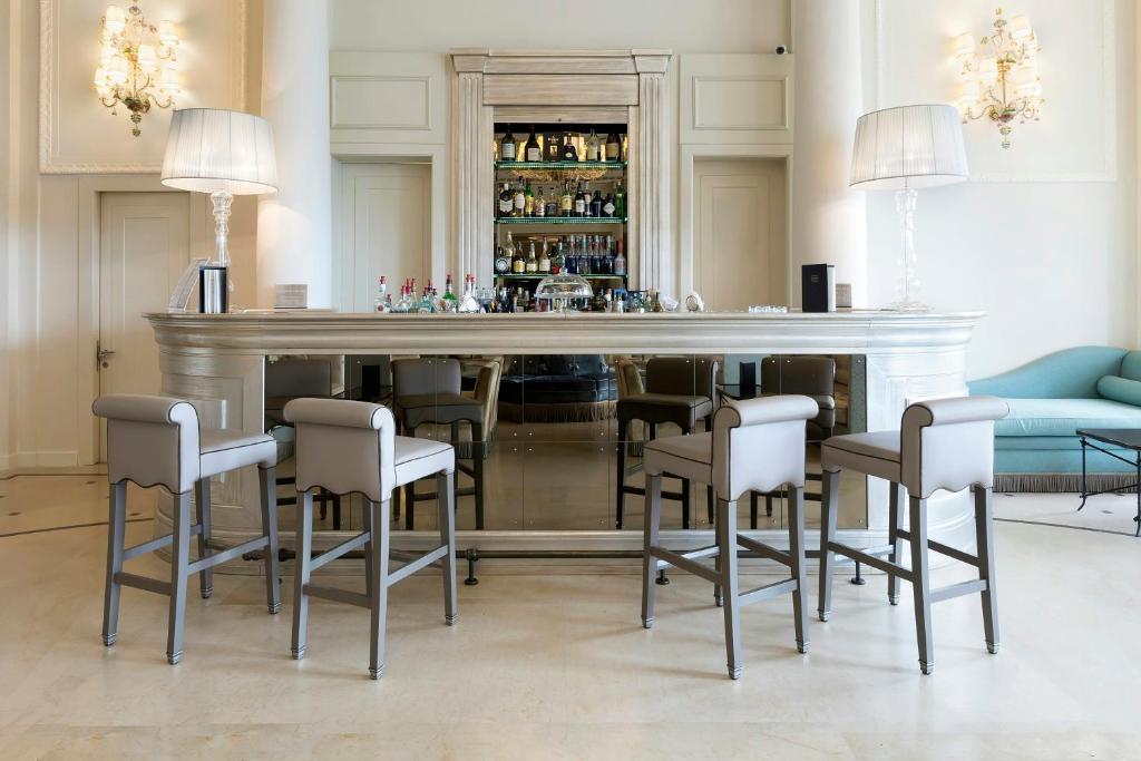 a bar in a room with chairs and a table at Savoia Excelsior Palace Trieste - Starhotels Collezione in Trieste
