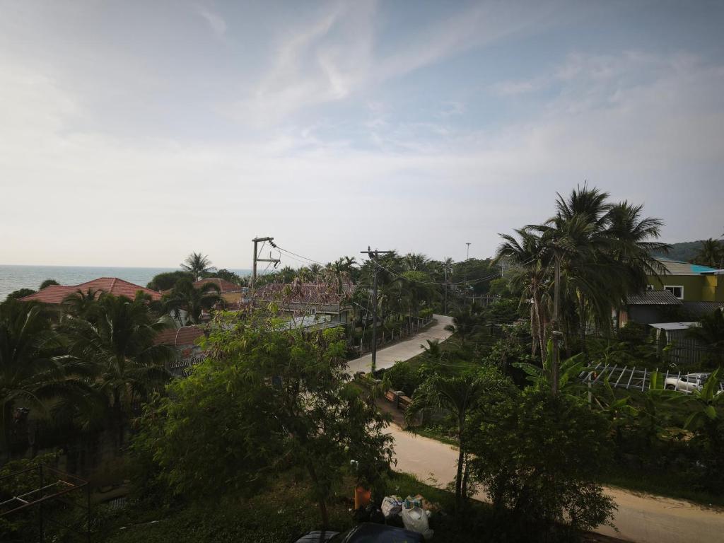 a view of a road with palm trees and the ocean at StayStable Guest House in Ko Lanta Yai