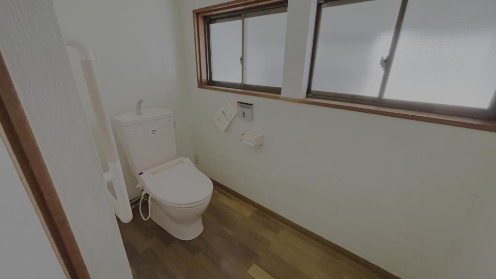 a bathroom with a toilet and a window at 萩市の静かな港町の一棟貸切宿 泊まれるカフェ 龍さん家 -Japanese traditional house- in Hagi