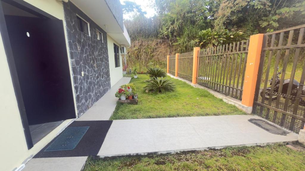 an open door of a house with a fence at Villa Mariaclaudia completa in Macas