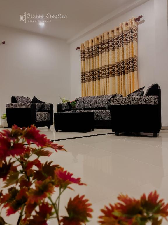 a living room with couches and a couch and flowers at Villa 592A - Hikkaduwa in Hikkaduwa