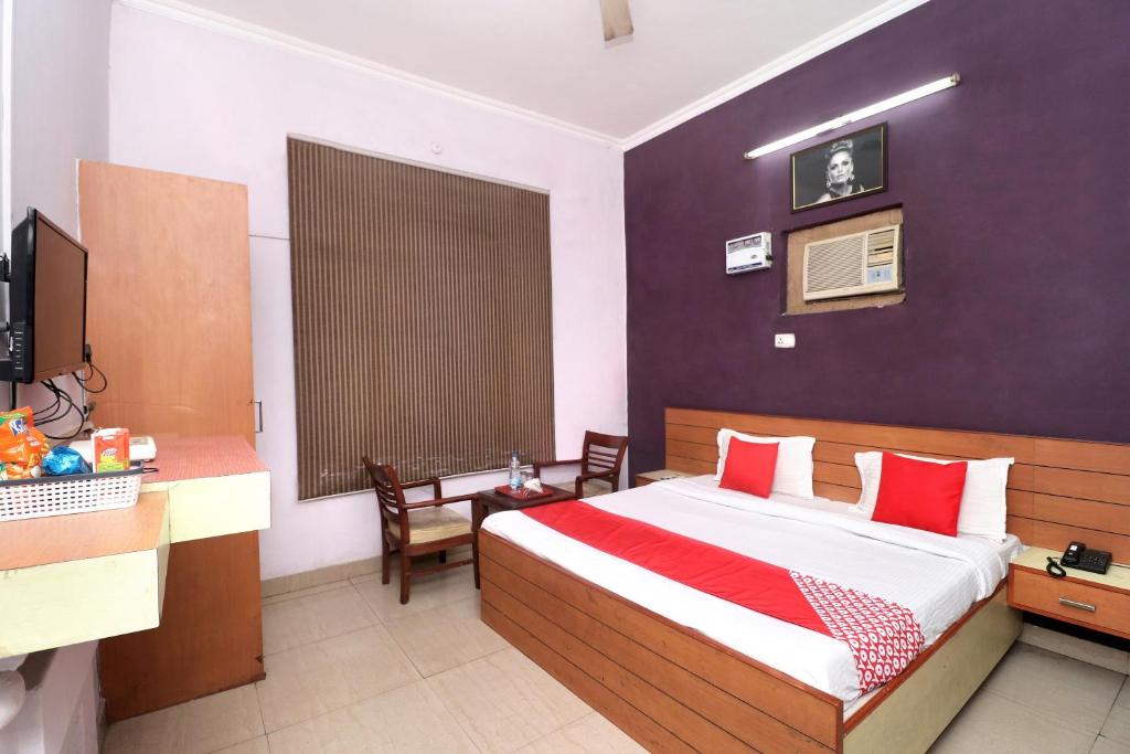 a bedroom with a bed and a desk and a television at Hotel O Star INN in Jalandhar