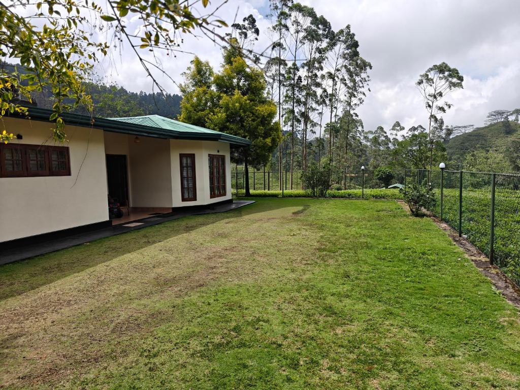 a house with a fence next to a yard at Watawala Tea Garden in Rozella