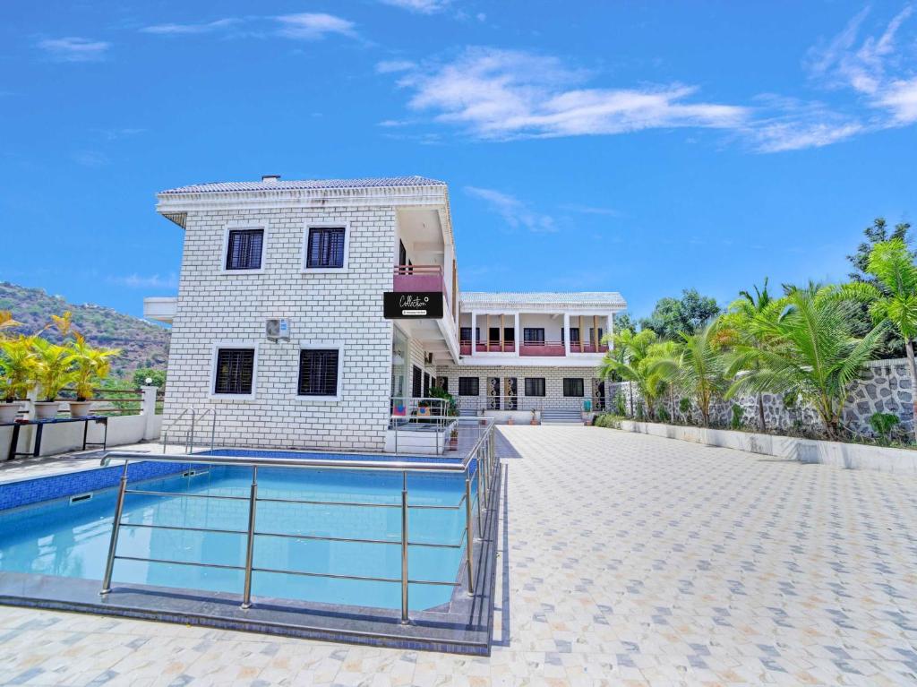 a house with a swimming pool next to a building at Collection O Daulatabad Fort Aurangabad Formerly JVS Park Inn in Daulatābād