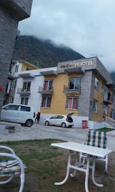 a building with a white bench in front of it at Kings Inn Hotel in Dargai