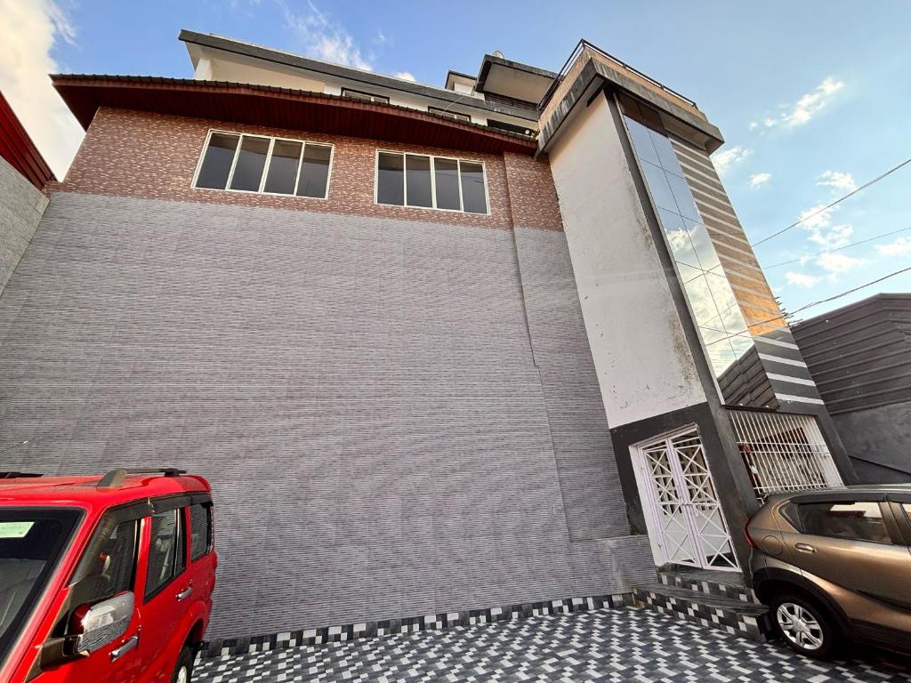 a red van parked in front of a building at Collection O Arya Vidyapeeth College Guwahati in Guwahati