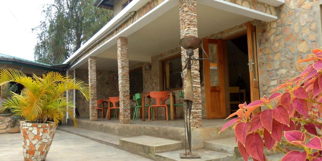 a porch of a house with chairs and tables at Dutchess Hotel and Restaurant in Fort Portal