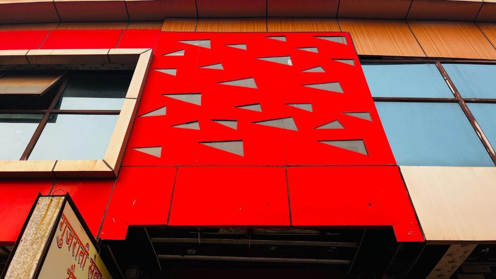 a red building with windows on the side of it at Hotel O Mathura Janam Bhumi Link Road in Bhuteshwar