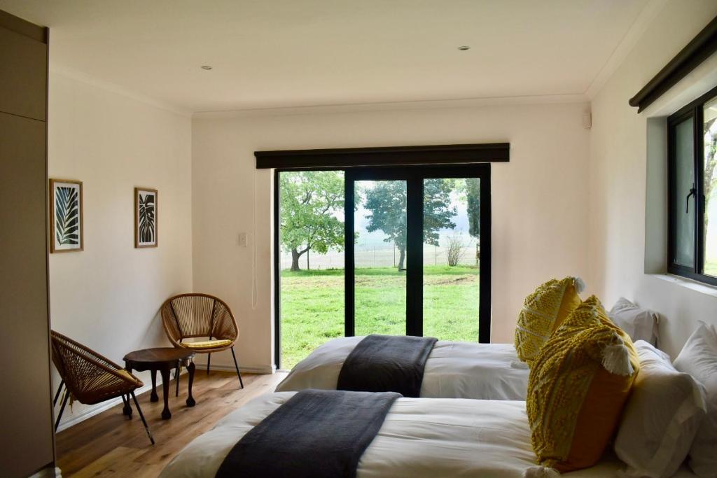 a bedroom with two beds and a large window at Mable's BnB 