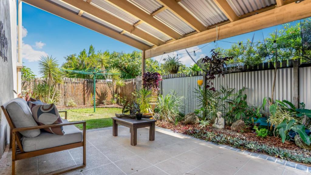 un patio extérieur avec une pergola et une chaise dans l'établissement The Infinite Pi Escape, à Bongaree