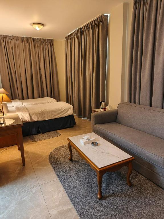 a living room with a couch and a bed at Kindi Suite Hotel in Amman
