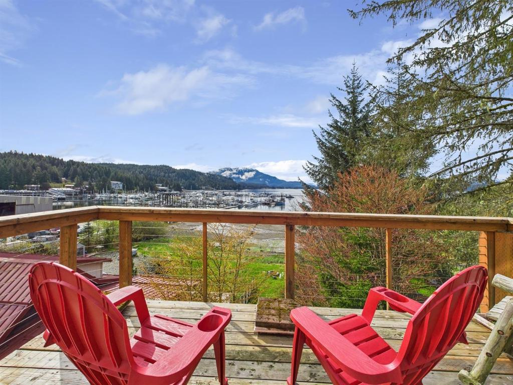 three red chairs on a deck with a view of the water at Family Getaway in Juneau, Alaska Unforgettable Ocean and Mountain Views in Mendenhaven