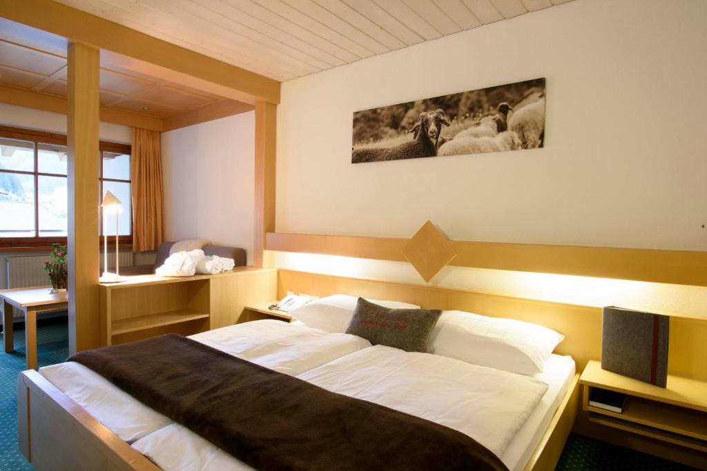 ein Schlafzimmer mit einem großen Bett in einem Zimmer in der Unterkunft Hotel Sonnblick in Gaschurn