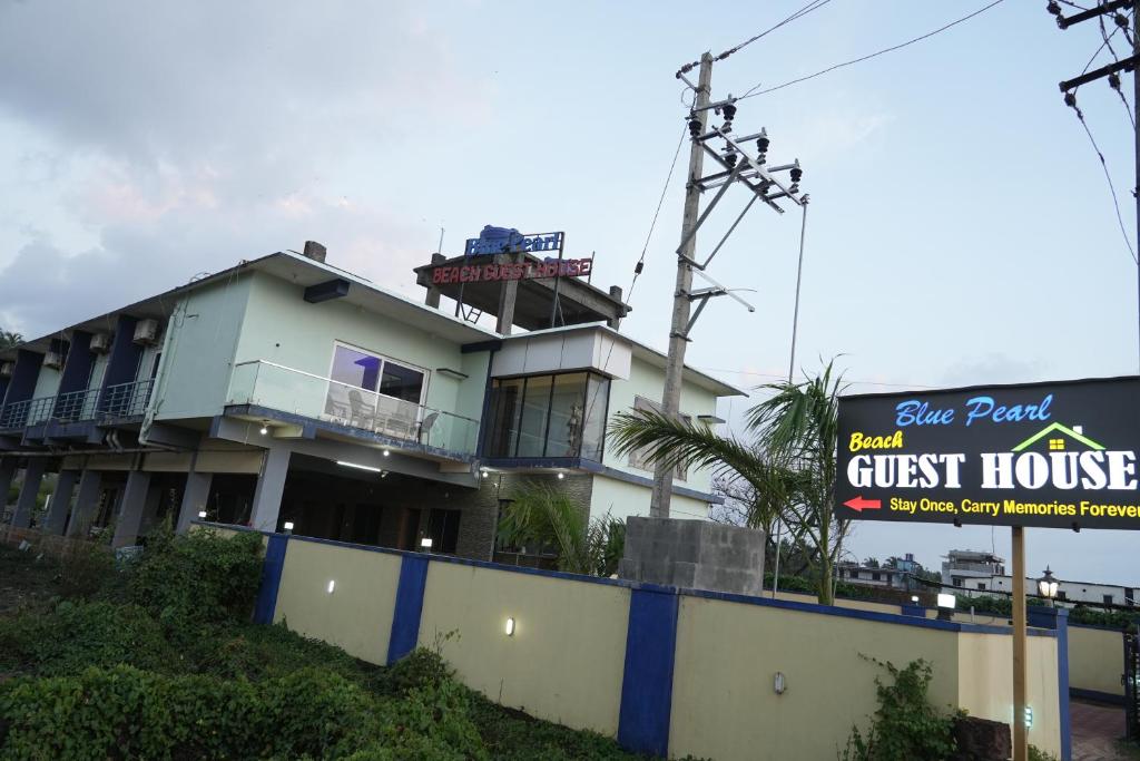 a guest house with a sign in front of it at Blue Pearl Beach Guest House in Māvalli