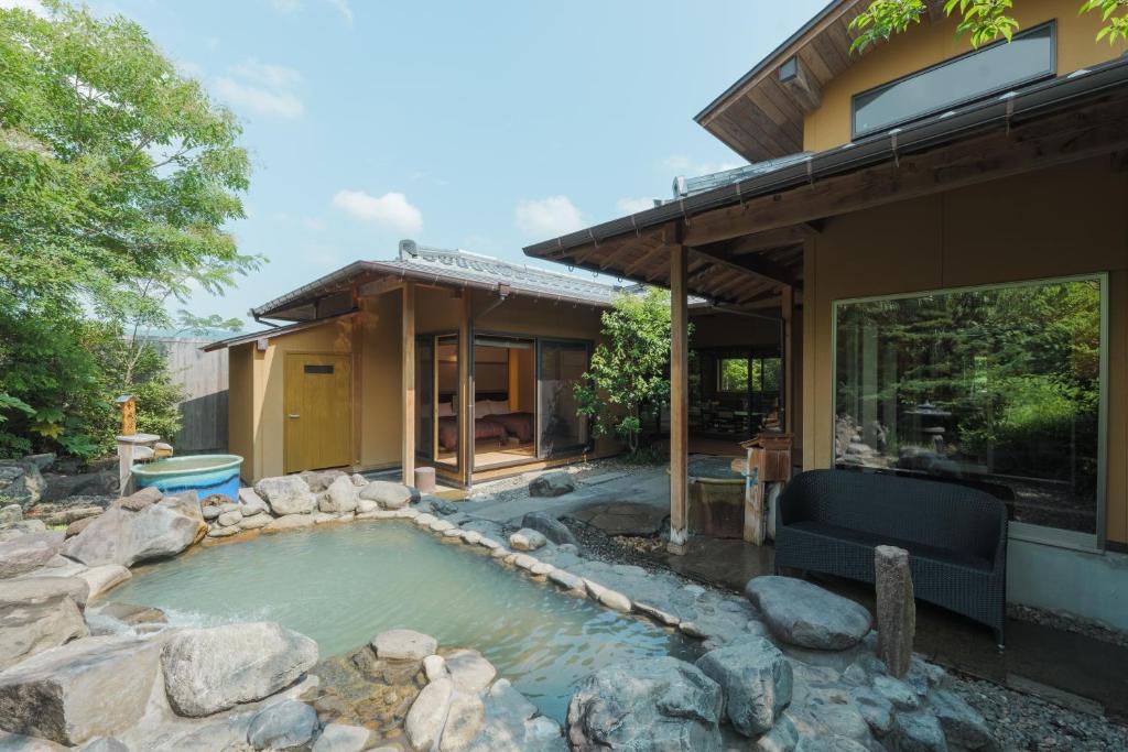 a hot tub in the backyard of a house at 四季の宿 明翠 in Kirishima