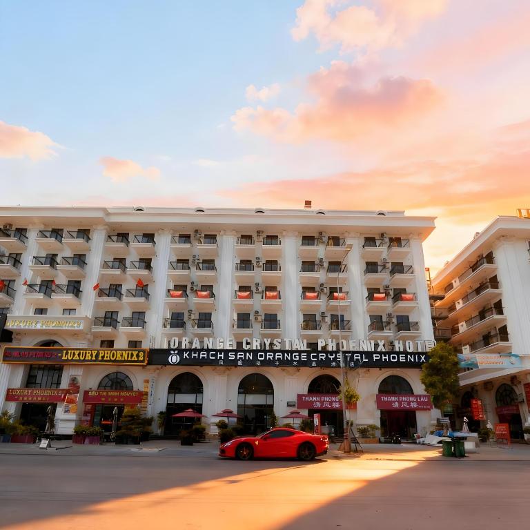 a red car parked in front of a building at Orange Crystal Phoenix hotel in Bắc Ninh