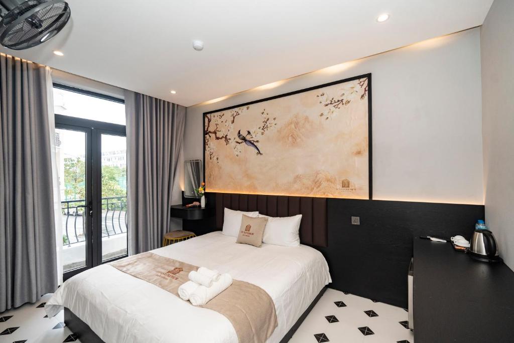 a bedroom with a bed and a large painting on the wall at Tuỳ Tâm Luxury Hotel Quảng Trị in Ðông Hà