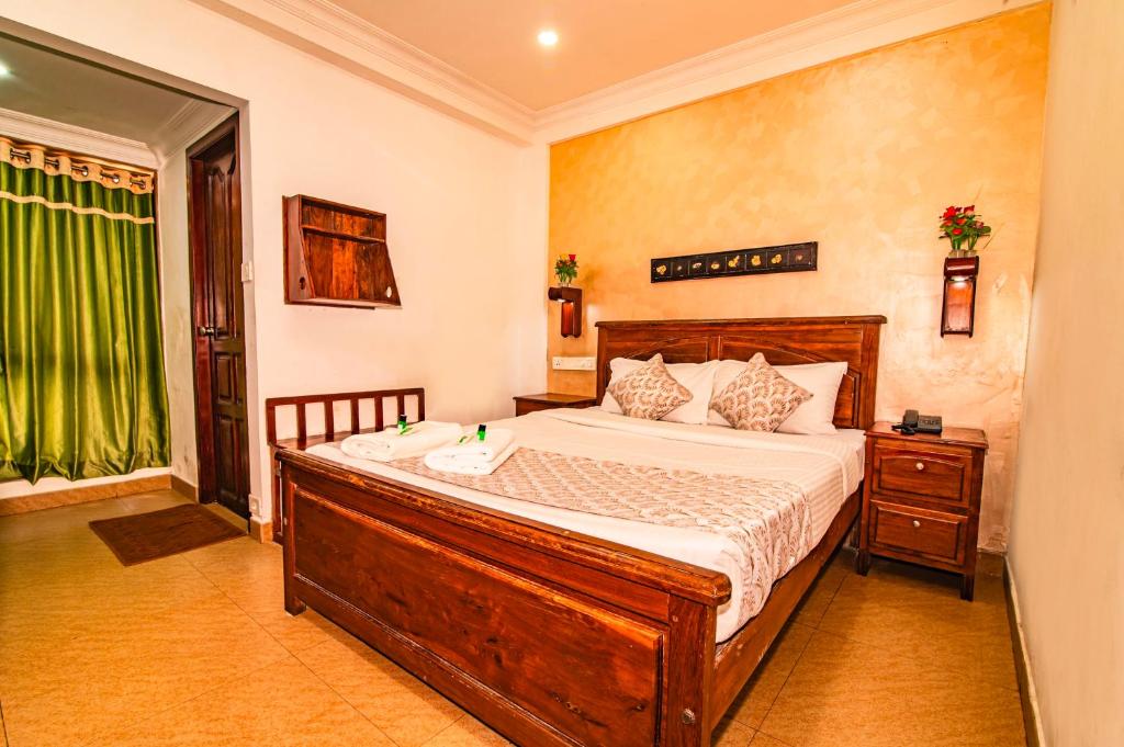 ein Schlafzimmer mit einem Bett und einem grünen Vorhang in der Unterkunft Hotel Mart View in Kochi