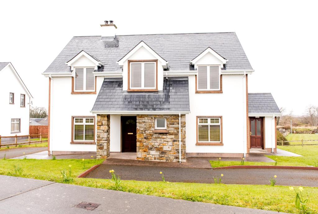 a white house with a gray roof at Duncarbury Heights - 4 Bedroom Detached House in Tullaghan