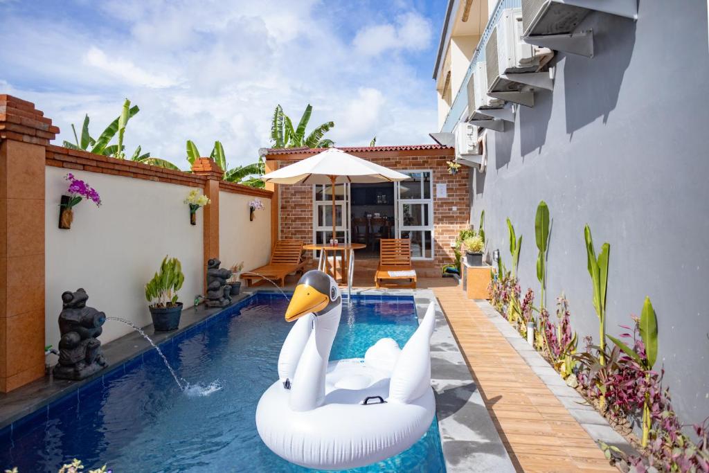 a pool with two swans in a house at Alam Canggu Kuta by ABM in Canggu