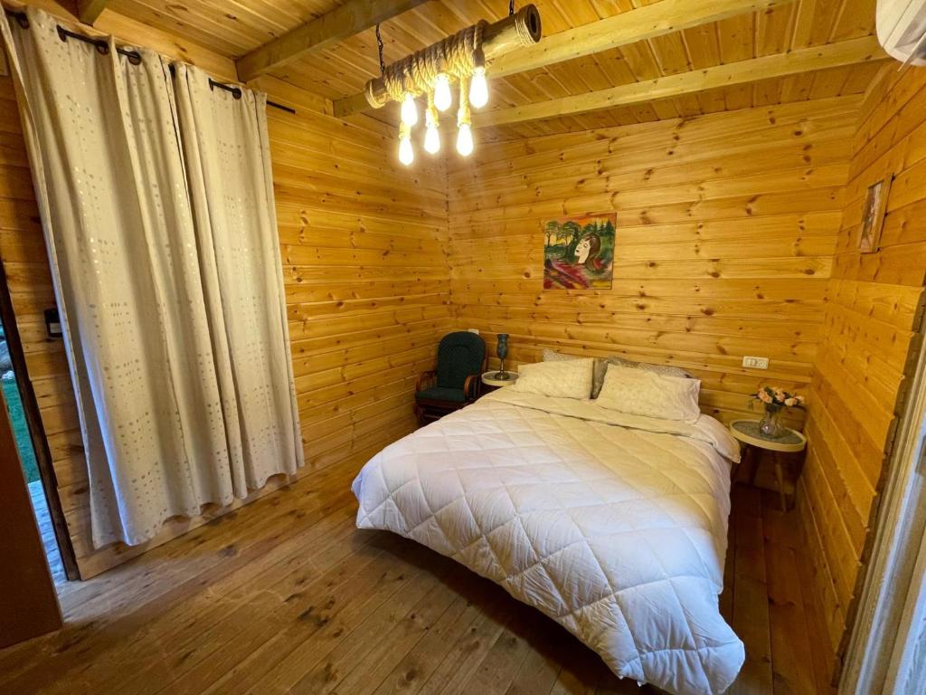a bedroom with a bed in a wooden cabin at Relax Home Nazareth Rawaqan 2026 منتجع روقان צמר נצרת in Nazareth