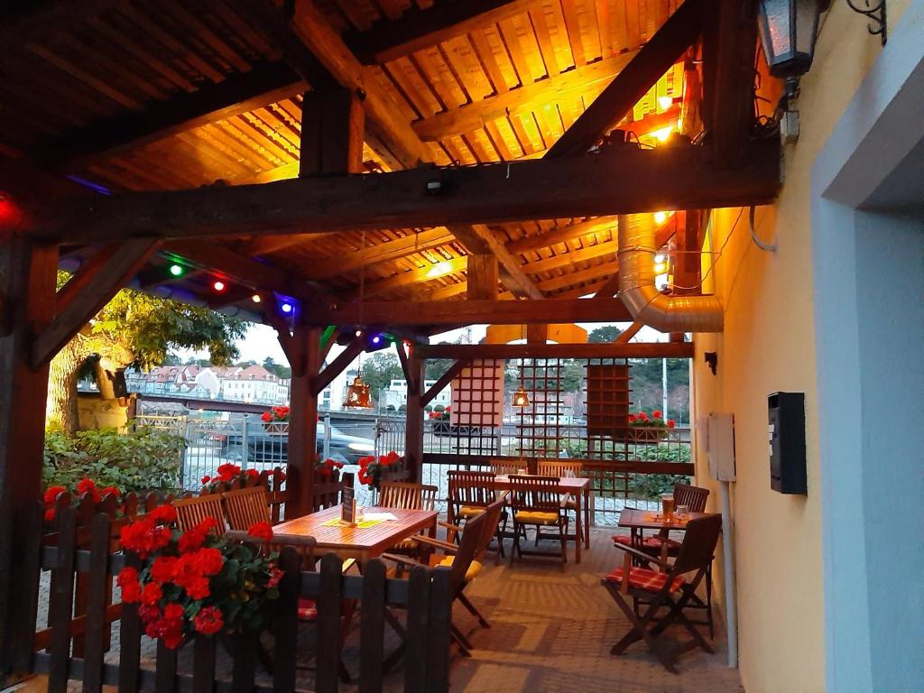 a restaurant with tables and chairs and a wooden ceiling at Fewo Am Triebischbrunnen in Meißen