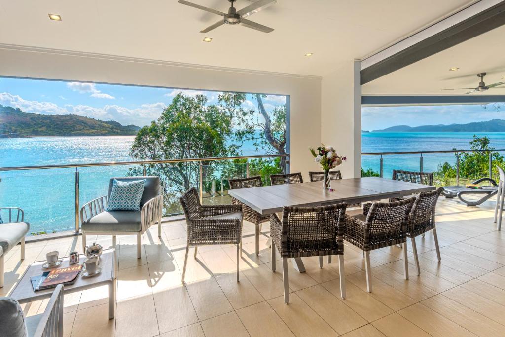 a dining room with a view of the ocean at Edge 2 - Oceanfront Luxurious and Spacious 4 Bedroom Split Level Apartment with buggy and valet service in Hamilton Island