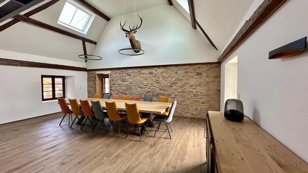 a dining room with a wooden table and chairs at Les 4 Fontaines in Osenbach