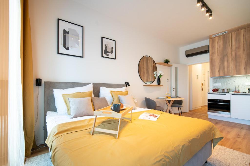 a bedroom with a large bed with a yellow blanket at apartino - free parking v okolí - in the neighbourhood, city view balcony, nespresso, netflix in Komárov